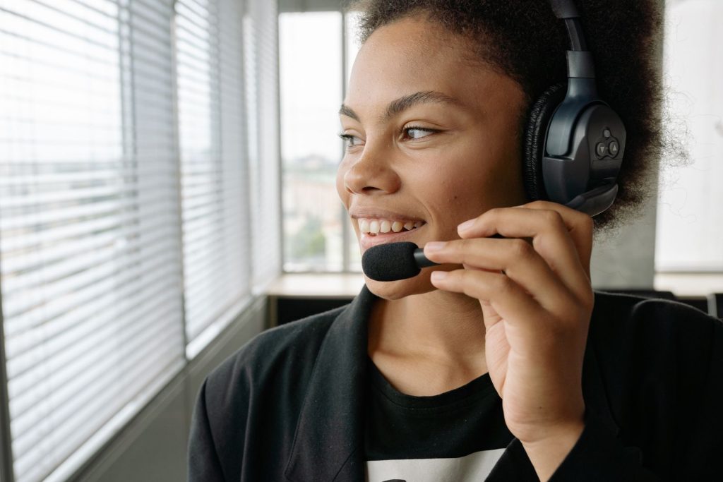 Smiling woman wearing a headset by a window