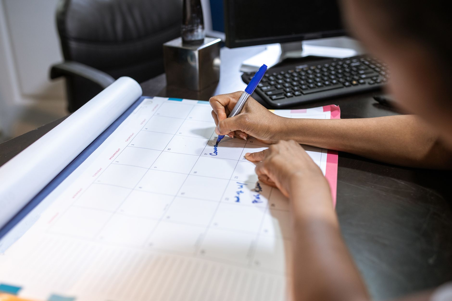 Woman planning schedule on desk calendar