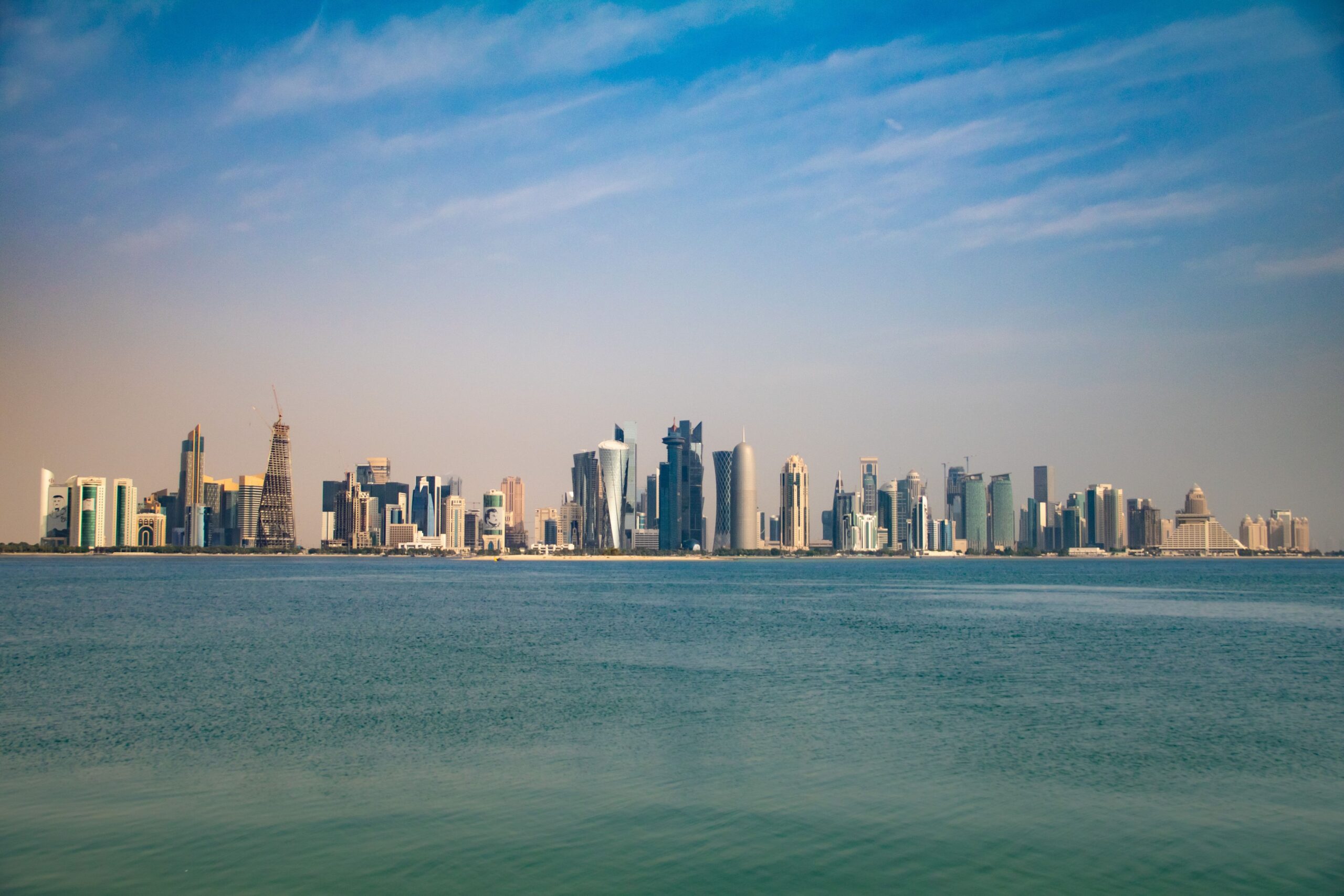 The Doha skyline seen from the Corniche under a clear blue sky, representing Qatar's national information assurance and cryptographic compliance landscape