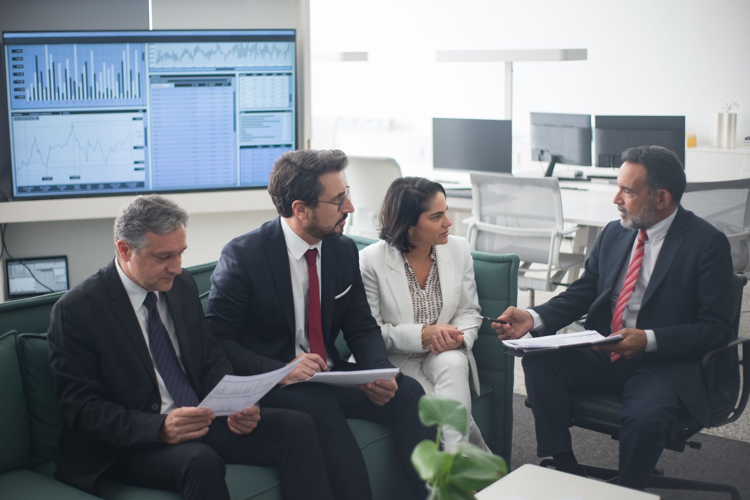 Group of financial services professionals discussing strategy in a modern office